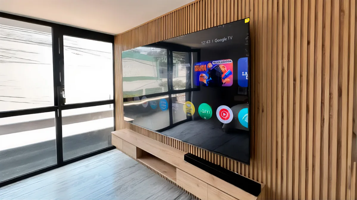 TV de 98 pulgadas instalado con rack fijo por Rack Forte en una sala con panel de madera